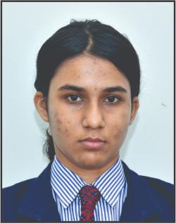 Portrait of a young woman in a school uniform looking at the camera; dark hair tied back, wearing a blue blazer, striped shirt, and red tie.