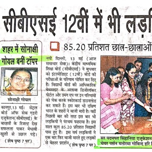 Hindi newspaper clipping featuring a portrait in a green bordered box on the left and a group photo at a ceremony on the right; headline notes 85.20% student pass rate.