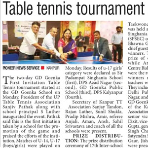 Officials and participants shake hands during a table tennis tournament awards ceremony; five people stand in a row beside a banner.
