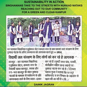 Poster 'Sustainability in Action' showing people in traditional dress performing a street play about a green, clean Kanpur; includes Hindi text and 'Dainik Jagran' logo.