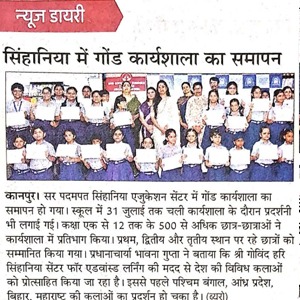 Group of students and teachers posing with certificates on a stage after a workshop closing ceremony.