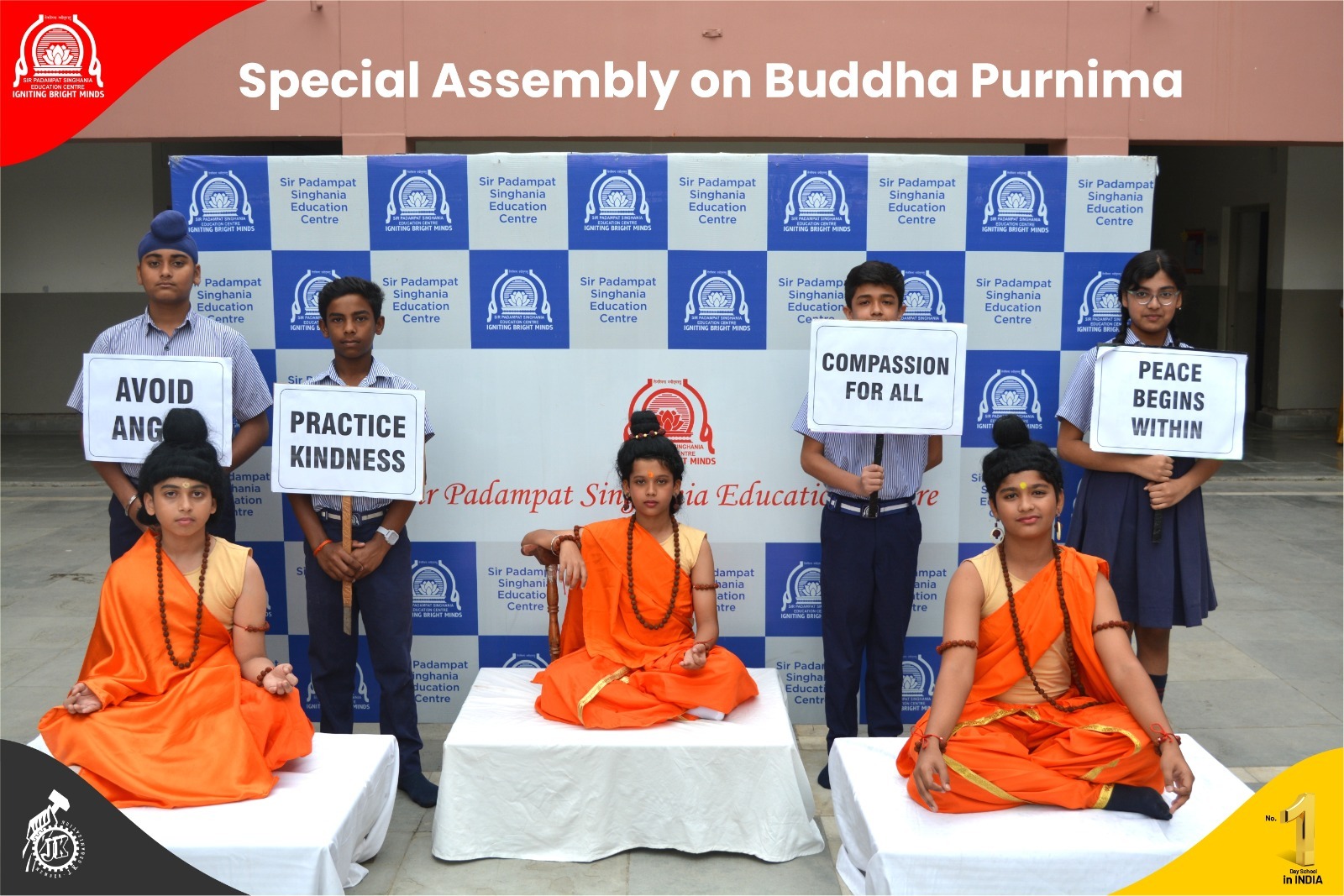 Students hold signs with messages like 'Avoid Anger', 'Practice Kindness', 'Compassion for All', and 'Peace Begins Within' during a Buddha Purnima assembly at Sir Padampat Singhania Education Centre.