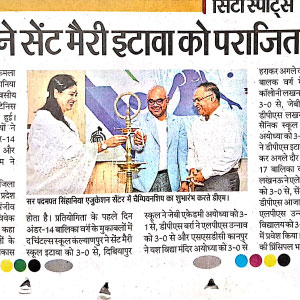 Woman in a white saree hands a trophy to a man in a light blue blazer as two men look on at an award ceremony in a newspaper photo.
